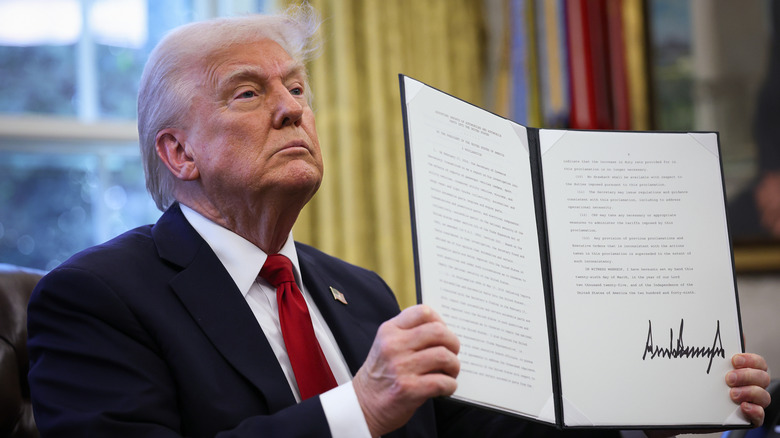 President Trump displays a ceremonially signed executive order issuing a 25% tariff on foreign auto imports in March 2025.