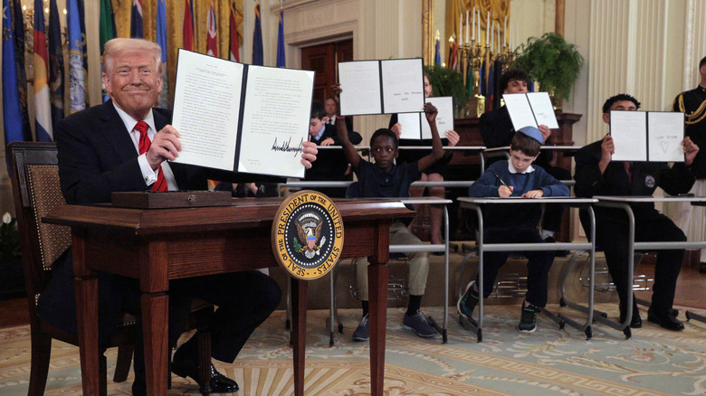Donald Trump holding a signed executive order