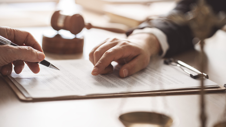 Two people signing paperwork.