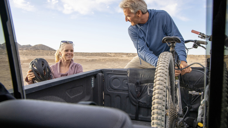 Retired couple unloading bicycles from pickup truck