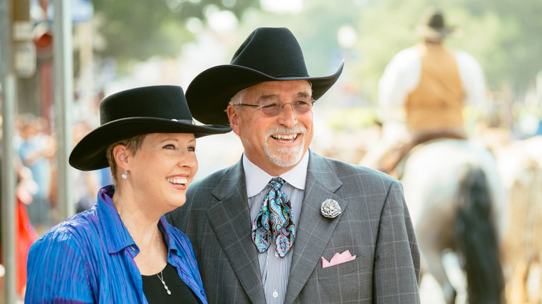 A smiling senior couple wearing cowboy hats