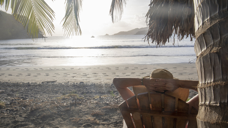 Person sitting on tropical beach