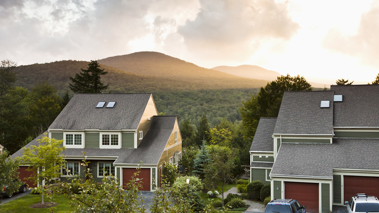 Homes surrounded by lush green hills at sunset