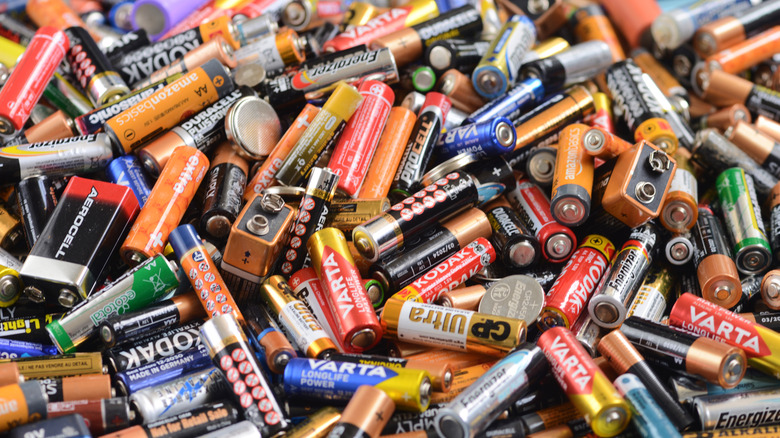 A large pile of assorted batteries