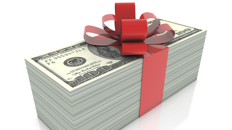 A stack of hundred dollar bins wrapped in a bow