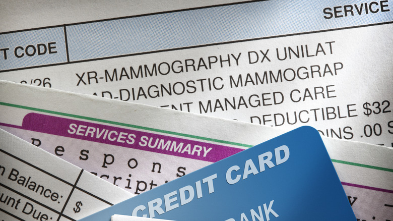 A credit card and a stack of medical bills