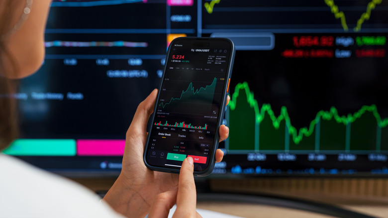 An investor looking at charts on smartphone