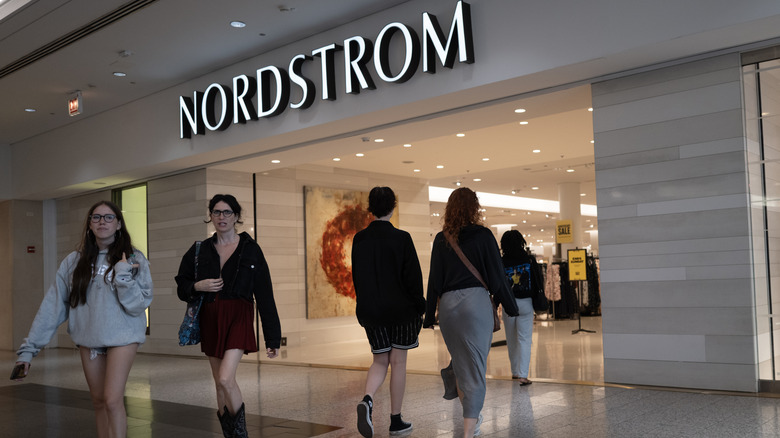 women in a mall walking in and out of Nordstrom