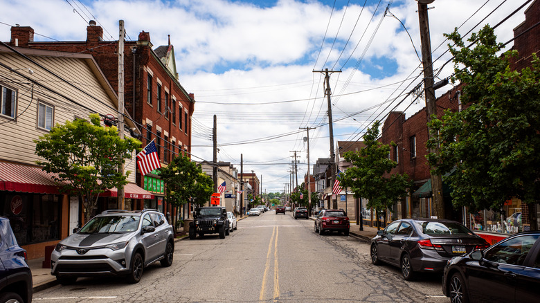 Street with cars shops and houses in Millvale