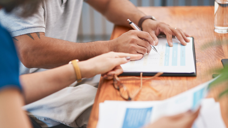 closeup of hands working on estate documents