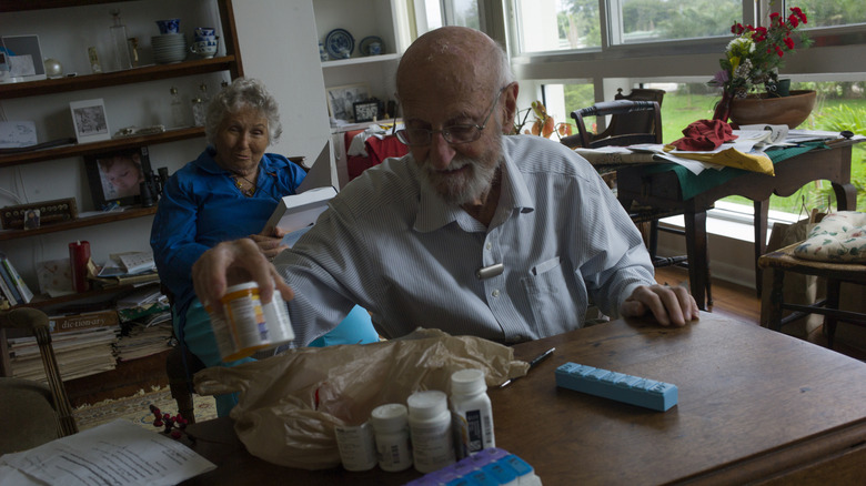 A 90-year-old retiree prepares pills for his wife in his Sarasota, Florida home in 2020.