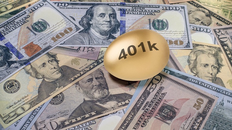 US dollar bills of varying values underneath a gold 401(k) egg