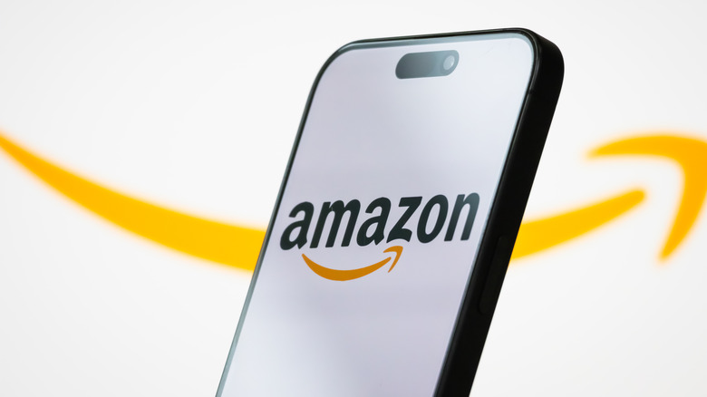 The logo of Amazon.com, Inc. is displayed on a smartphone screen,