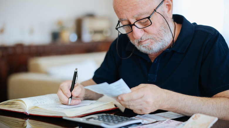 A mature man looking at receipts