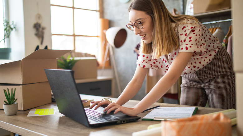 person smiling, working at laptop