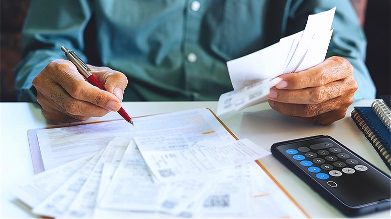 Person holding receipts, calculating paperwork