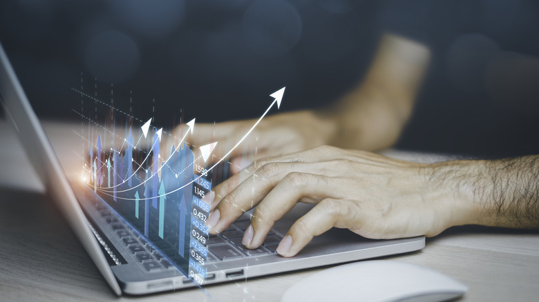 increasing financial charts overlaid on a laptop