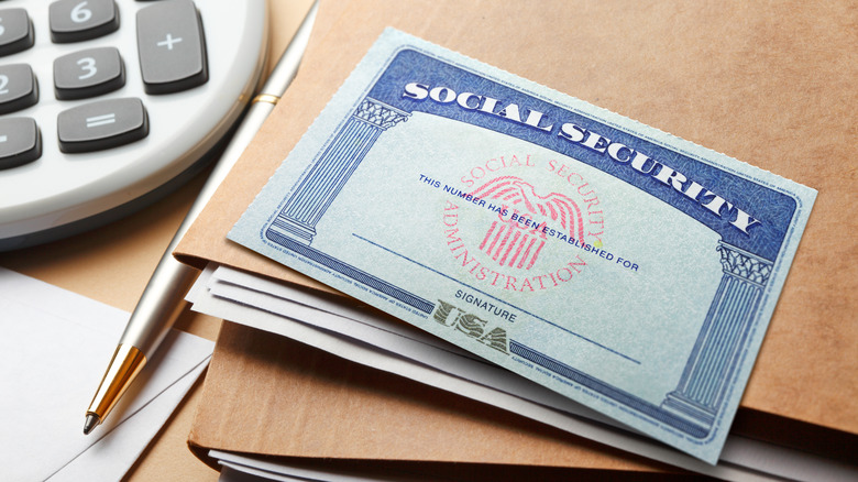 Social Security card on top of files next to calculator