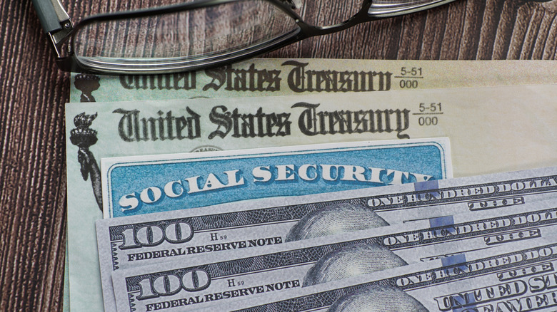 Social security checks alongside $100 bills