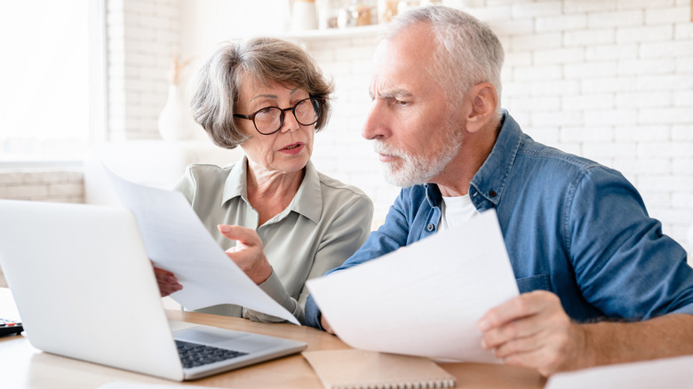 A retired couple examining documents together