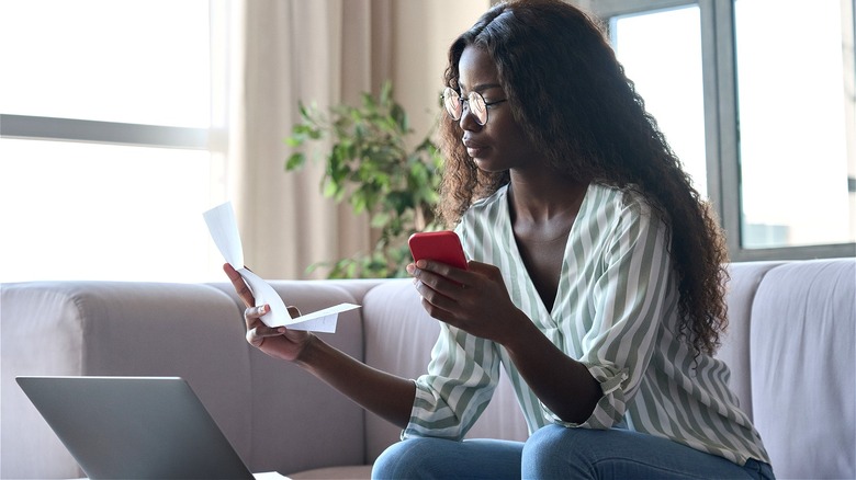 Person holding cellphone, reading letter