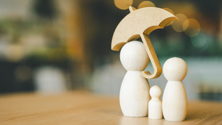 people figurines holding an umbrella