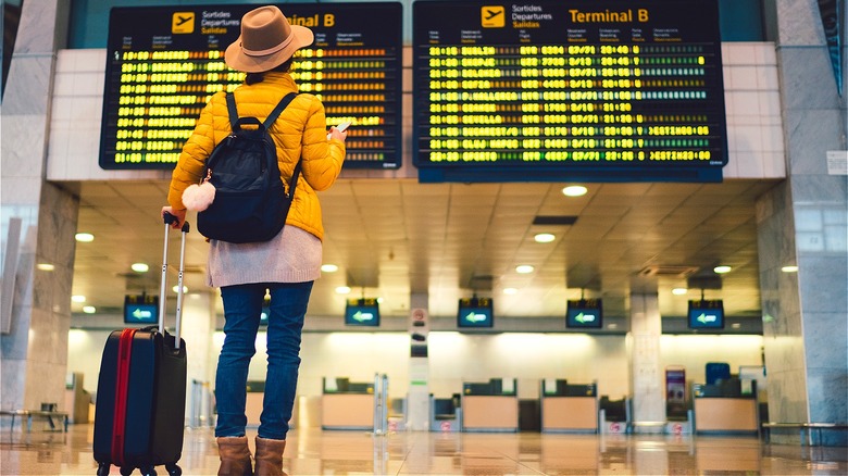 Person checking airport flight schedules