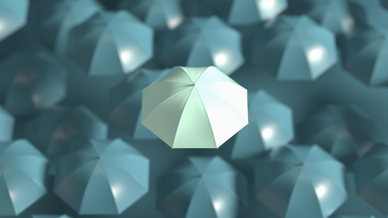 Umbrella standing out from crowd