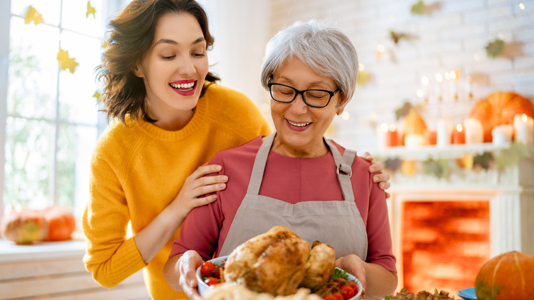 Mother and daughter smiling with cooked turkey
