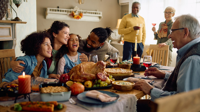 Smiling family with turkey on a table