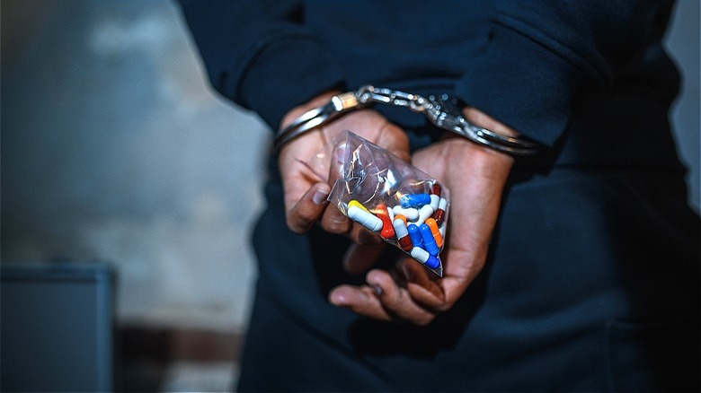 Handcuffed criminal with drugs