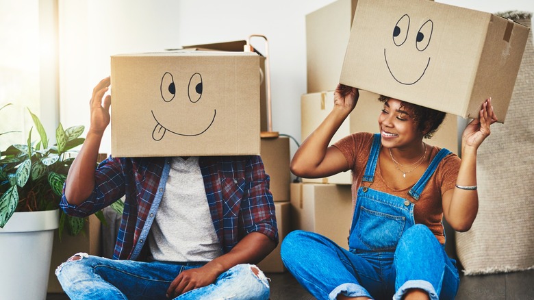 homeowners wearing boxes on their heads while unpacking