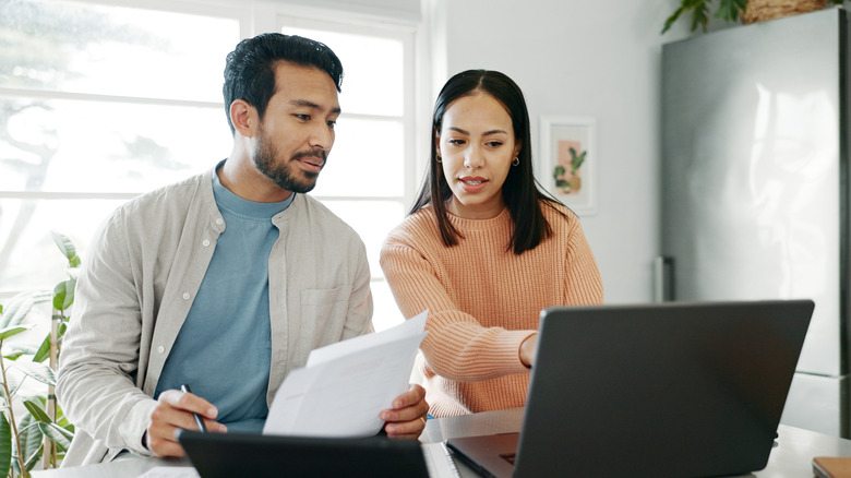 Couple at kitchen counter working on finances