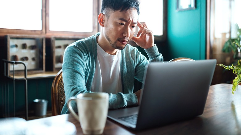 Person looking at laptop suspiciously
