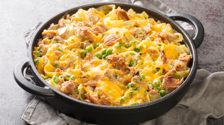 An attractive cast-iron skillet full of cheesy tuna noodle casserole.