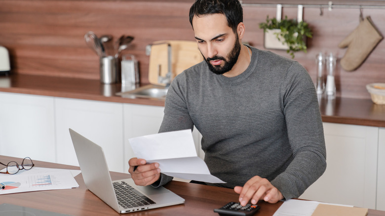 Man looking over papers computer