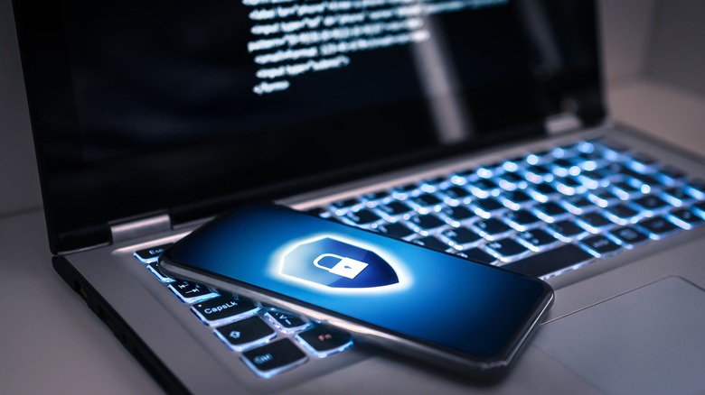 Phone on computer with cybersecurity screen