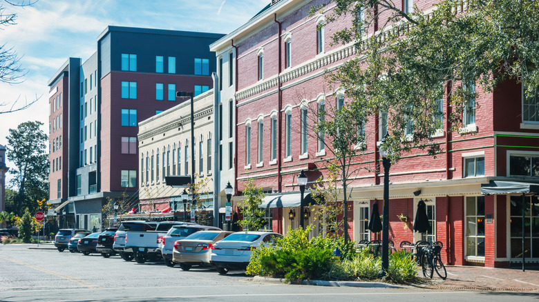 Restaurants and businesses along the street with parked cars in Gainesville
