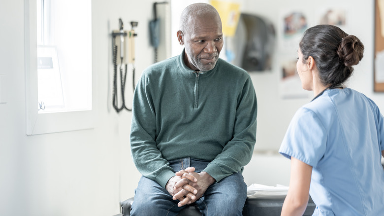 man on doctor table with nurse