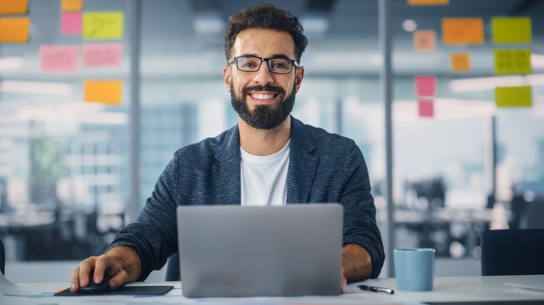 man smiling with a laptop