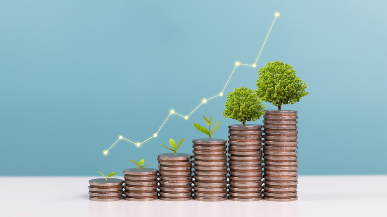 trees growing on increasingly large stacks of coins