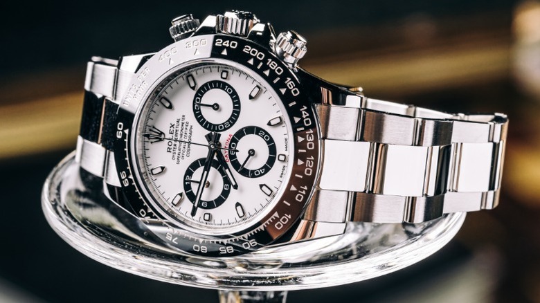 A Rolex Cosmograph Daytona on display on a small stand.