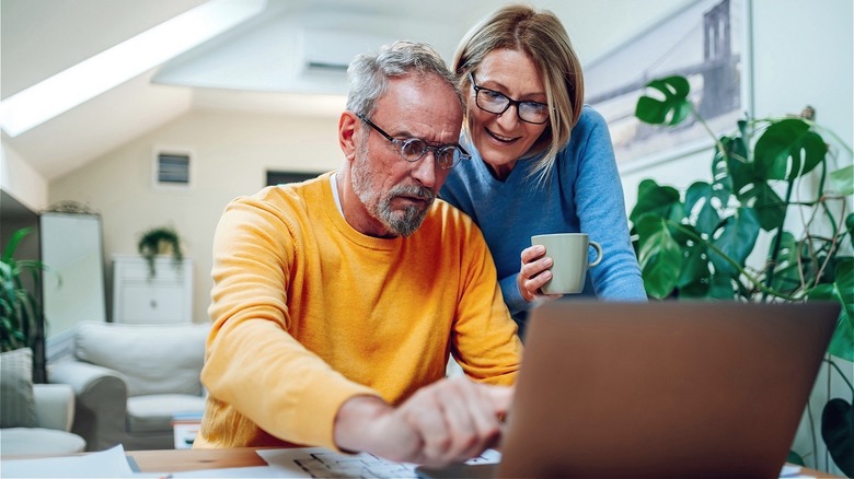 Middle-aged couple reading from laptop