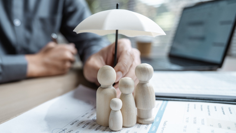 family of figurines under an umbrella