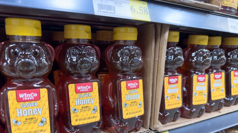 A shelf full of WinCo brand honey bottles
