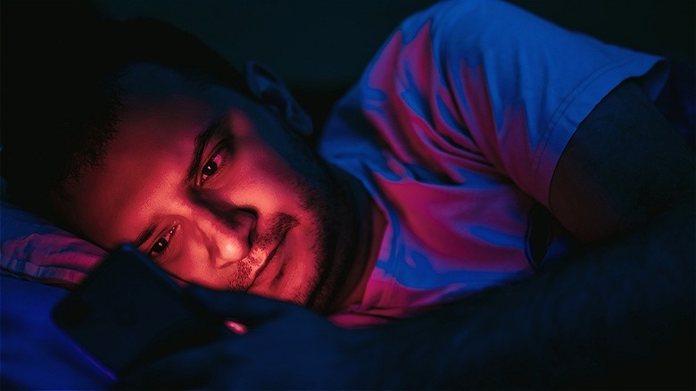 Person using phone in bed