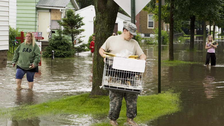 A family walking through flood water after evacuating their home
