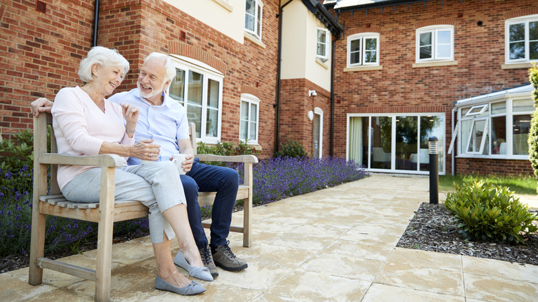Senior couple sitting on a bench outside a brick building