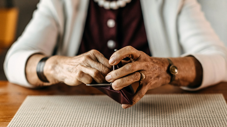 Elderly woman holding coin purse