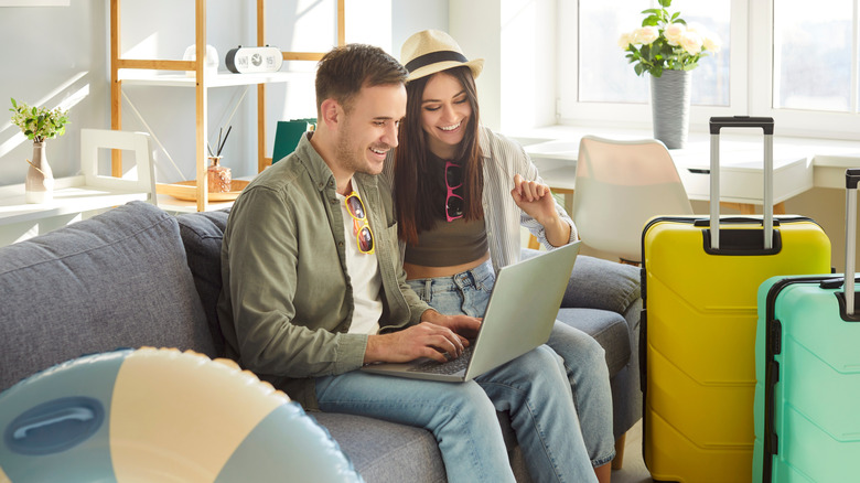 Couple planning vacation on computer.